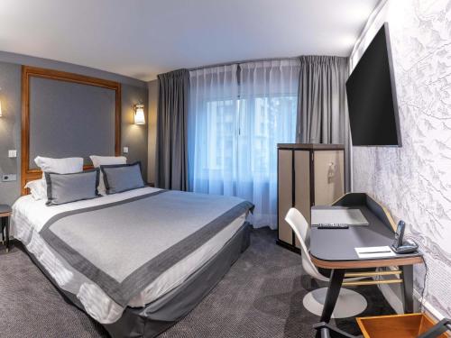a hotel room with a bed and a desk and a computer at Park Hotel Grenoble - Handwritten Collection in Grenoble