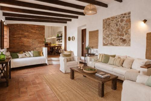 a living room with white furniture and a brick wall at Monte da Lagoa in Altura