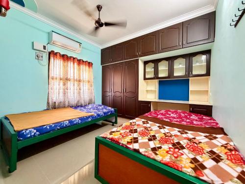 a bedroom with two beds and a window at Royal Paradise Inn in Chidambaram