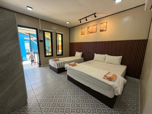 a hotel room with two beds and a couch at Khafii House in Kampong Pasir Panjang