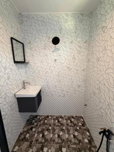 a bathroom with a sink and a mirror at Khafii House in Kampong Pasir Panjang