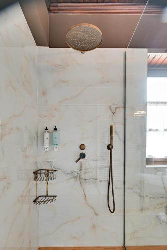 a bathroom with a shower with white marble walls at Frontzu Politia in Ioannina