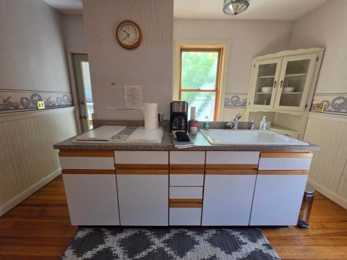 a kitchen with a sink and a clock on the wall at Mrs Hippie Inn in Alma