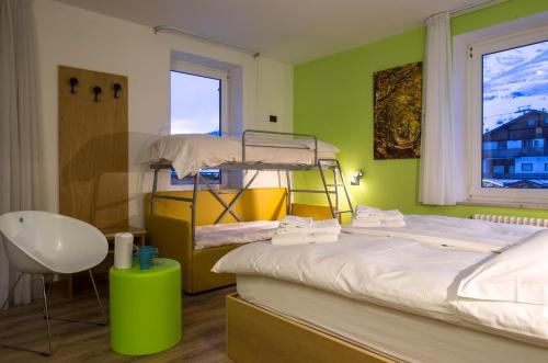 a bedroom with two bunk beds and a chair at Alpencolor Hotel Tonale in Passo del Tonale