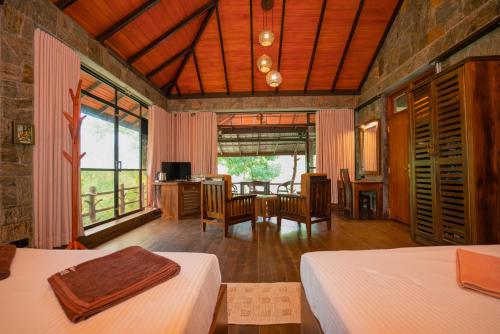 ein Schlafzimmer mit zwei Betten und ein Esszimmer mit einem Tisch in der Unterkunft Tea Cottage Resort - Nawalapitiya in Kandy