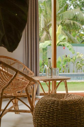 a table and a chair next to a window at Hide Boutique Villas in Weligama
