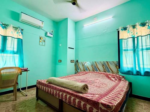 a bedroom with a bed in a room with blue walls at Divine Homestay by EDAC in Chidambaram