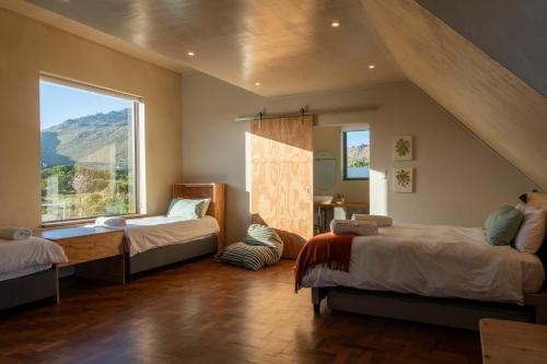 a bedroom with two beds and a large window at The Dunes Pringle Bay in Pringle Bay