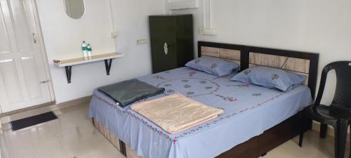 a bedroom with a large bed with blue pillows at Kanchan Grace in Vaduvanchal
