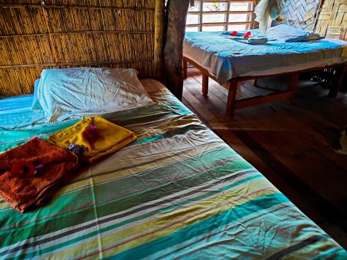a room with two beds and a table with a bedskirtspectspectspectspects at Montanna bungalow in Lénakel