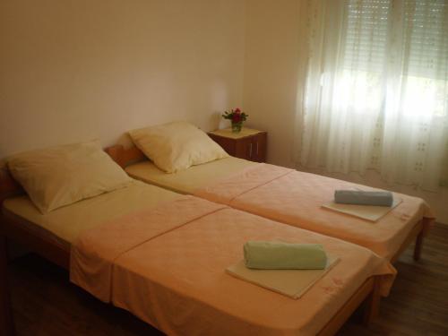 1 Schlafzimmer mit 2 Betten, Handtüchern und einem Fenster in der Unterkunft Apartment Vuk i Novak in Ulcinj