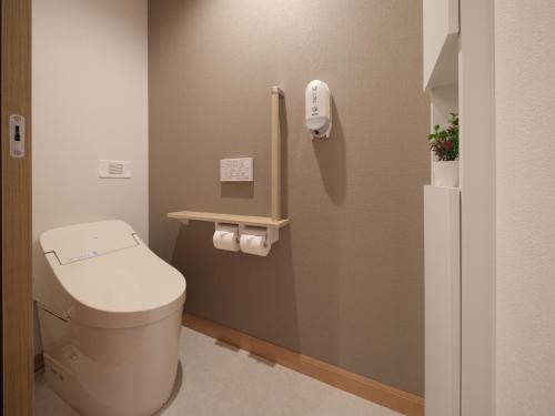 a bathroom with a toilet and a phone on the wall at マークヴィラ松本 in Matsumoto