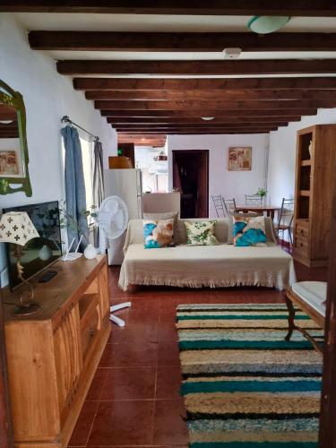 a living room with a bed and a table at Cortijo Paraiso Pool & Tropical Garden Oasis in Cúllar de Baza