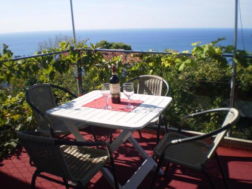 a white table with two chairs and a bottle of wine at Apartment Vuk i Novak in Ulcinj