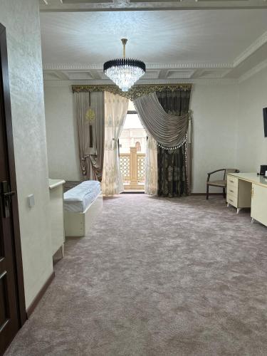 a large room with a bed and a chandelier at Premium Ark Hotel in Bukhara