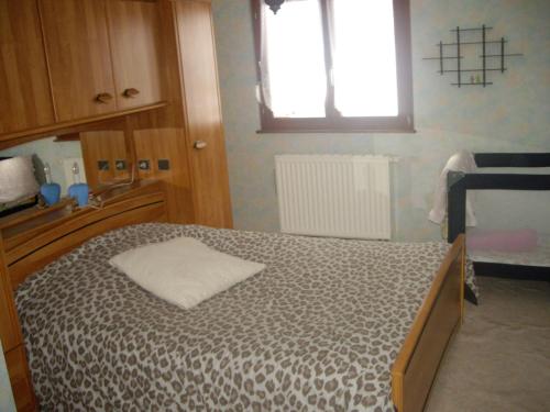 ein Schlafzimmer mit einem Bett in einem Zimmer mit einem Fenster in der Unterkunft appartement vue sur la montagne in Soultzeren