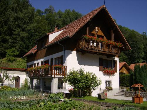 una gran casa blanca con flores en los balcones en appartement vue sur la montagne, en Soultzeren