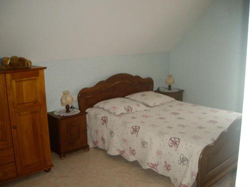 1 dormitorio con cama y tocador de madera en appartement vue sur la montagne, en Soultzeren