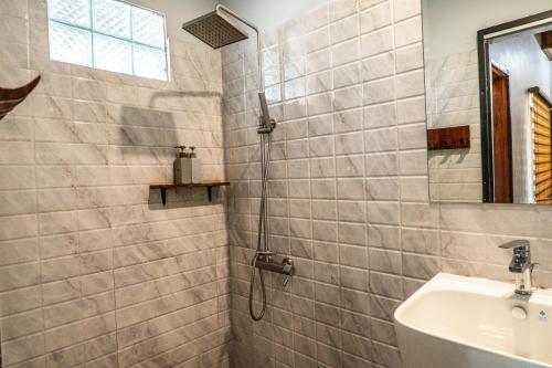 a bathroom with a shower and a sink at Highland Park Mondulkiri in Phumĭ Pu Klé (2)