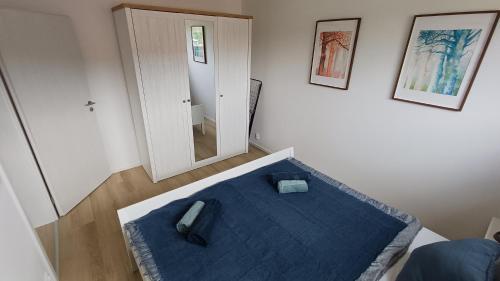 a bedroom with a blue bed and a mirror at Apartment Karlštejn Castle View in Karlštejn