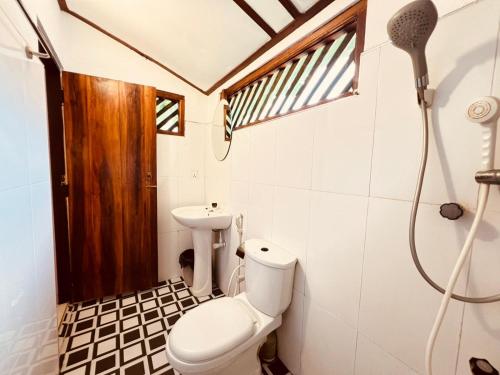 ein Badezimmer mit Toilette und Waschbecken in der Unterkunft Sandy Beach Hotel in Arugam Bay