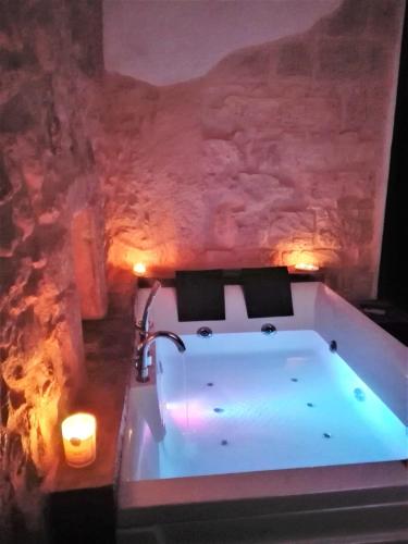 a bath tub in a room with a stone wall at Only for two Giumbabulla in Ragusa