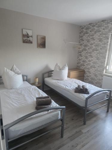 a bedroom with two beds and a brick wall at Ferienhaus Anna in Übach-Palenberg