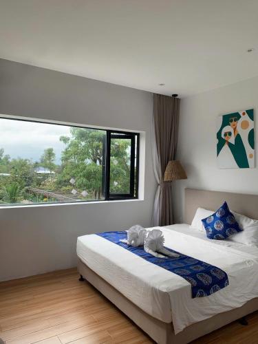 a bedroom with a bed with two stuffed animals on it at Dreamers Farm in Vinh Thanh