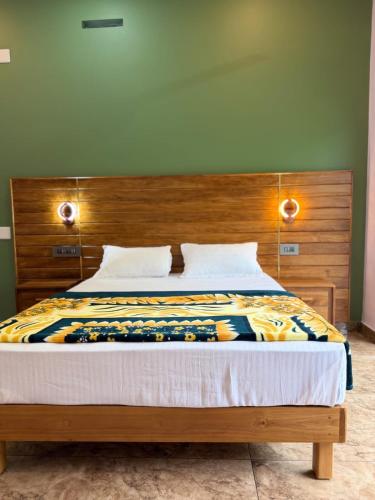 a bedroom with a bed with a wooden headboard at Bella Casa in Vagamon
