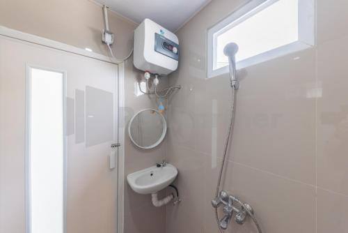 a bathroom with a shower and a sink at Adam Guesthouse Mitra RedDoorz in Bogor