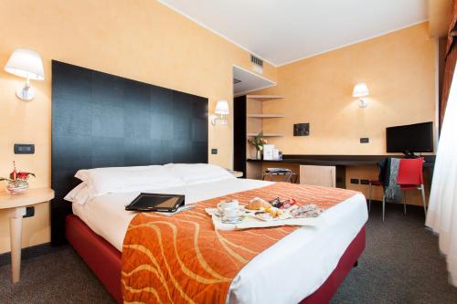 a hotel room with a bed with a tray of food on it at Hotel Majorana in Rende