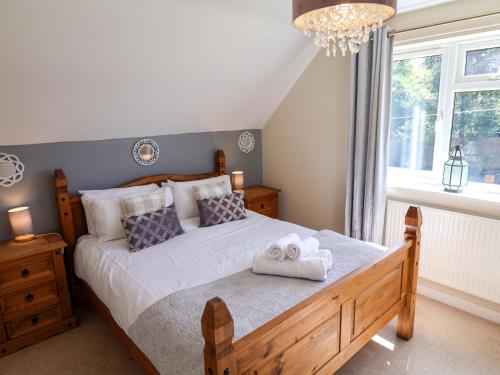 a bedroom with a bed with two towels on it at Rosemarie Annexe in Axminster