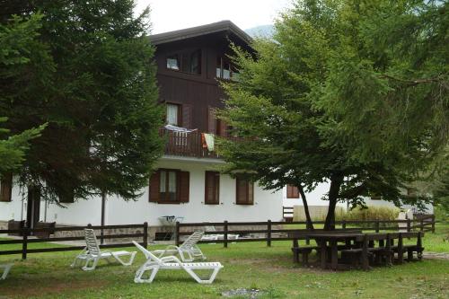 un groupe de chaises devant un bâtiment dans l'établissement Casa Pineta, à Ledro