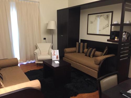 a living room with a couch and a chair at Terrazza Marconi Hotel&Spamarine in Senigallia