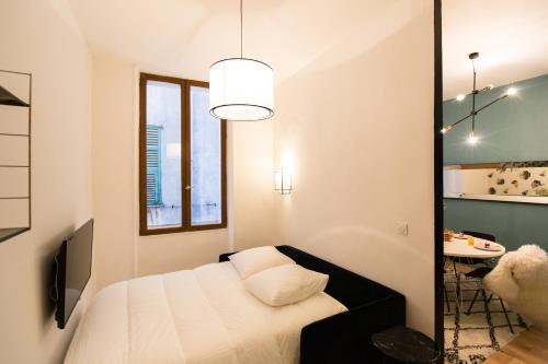 a small bedroom with a bed and a table at Moulin -Old Town in Nice