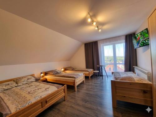 a room with three beds and a balcony at Cichy Potok in Polańczyk