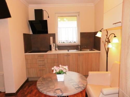 ein Wohnzimmer mit einem Tisch und einer Küche in der Unterkunft Aparthotel Guzulka & Restaurant in Berlin