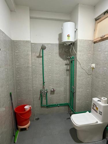 a bathroom with a shower with a toilet and a bucket at Hotel Devachan & Restaurant in Tāndi