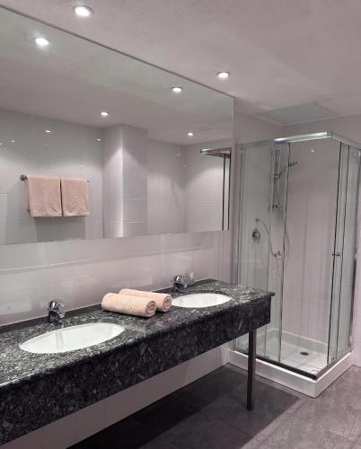 a bathroom with two sinks and a shower at Hotel Pause - Free WiFi & Free Parking!! in Hofheim am Taunus