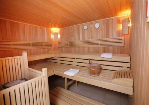 a sauna with two benches and a bucket in it at Le Green in Levernois