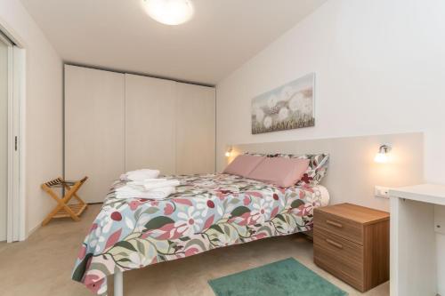 a small bedroom with a bed and a dresser at Al Col de Foia in Agordo