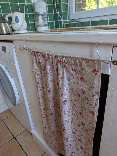 a bathroom with a sink and a washing machine at La Maison du temps retrouvé in Berville