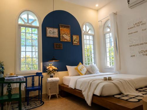 a bedroom with a large bed with a blue wall at Green Hillside Villa Hue in Hue