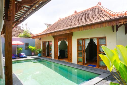 a villa with a swimming pool and a house at Villa Joglo Kawung - City Centre Paradise with Pool in Yogyakarta