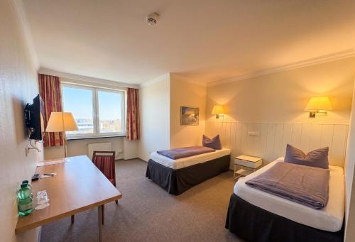 a hotel room with two beds and a desk at Hotel Pause - Free WiFi & Free Parking!! in Hofheim am Taunus