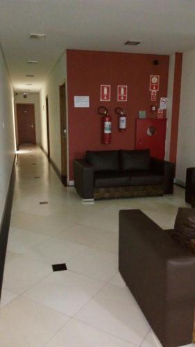 a living room with a black couch and a red wall at Hotel ZM Premium in Cosmópolis