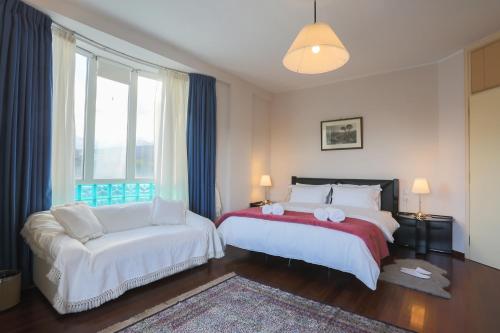 a bedroom with two beds and a couch at Villa Magnolia in Ioannina
