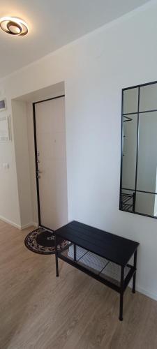 a black bench in a room with a mirror at Uueka Külaliskorter in Kuressaare