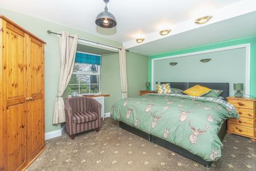 a bedroom with a bed and a chair and a window at Navitie Apartment in Ballingry