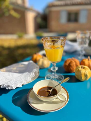 a cup of coffee and a glass of orange juice on a table at Audaces Resort in Recanati
